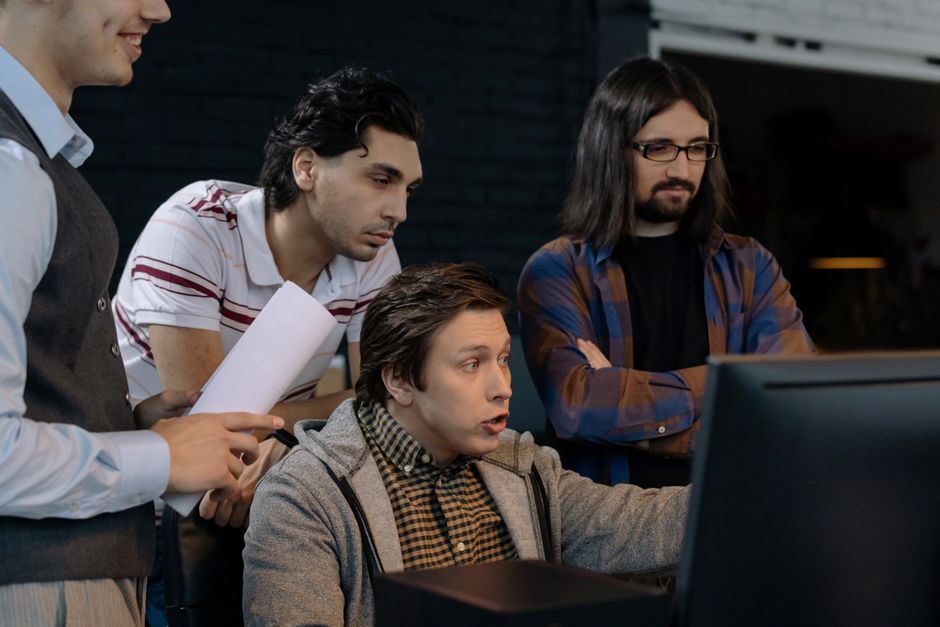 A diverse group of adults working together in a modern office environment, showcasing teamwork and collaboration.